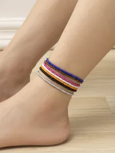 Gros plan de chevillères en perles colorées multicouches portées, style bohème détail.