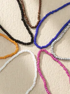 Détail de chaînes de cheville élastiques colorées avec des perles vibrantes de style bohème.