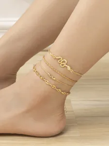 Gold layered anklet set detail shot featuring rhinestone snake pendant and chains.