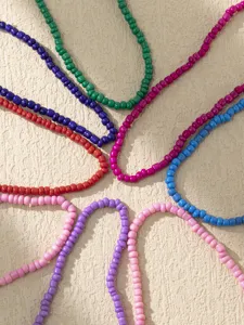 Vue de détail de chevillère en perles colorées, ensemble de bracelets élastiques aux perles vives.