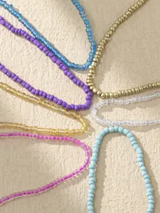 Gros plan détaillé de chaînes de cheville de perles bohèmes colorées aux teintes vibrantes.