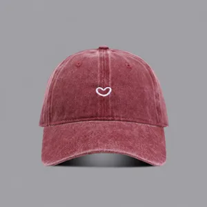 Close-up detail of the vintage washed cotton baseball cap featuring cute heart embroidery.