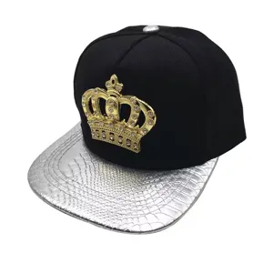 Detailed view of black hip hop hat with silver snake skin brim and gold rhinestone crown badge.