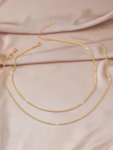 Close-up detail of double layered gold delicate shimmer clavicle chain necklace minimalist style.