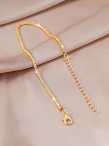 Delicate gold-plated chain necklace detail shot, showcasing shimmering metal luster.