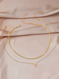 Elegant double layer gold-tone cross pendant necklace, minimalist shimmering clavicle chain.