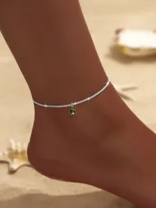 Nahaufnahme Detail der funkelnden Silber Kette Fußkettchen mit grünem Edelstein Anhänger.