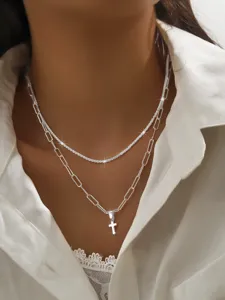 Detail shot of double layer silver necklace with sparkle chain and cross pendant for women.
