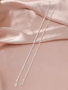 Detailaufnahme einer glitzernden filigranen Silberkette mit Karabinerverschluss.