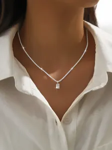 Delicate silver clavicle chain with shimmering rectangular crystal pendant close-up view detail