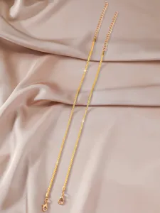 Feine goldfarbene Glitzerkette im Detail, filigrane Metallarbeit mit Karabiner.