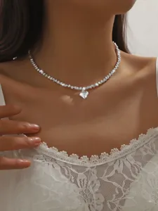 Close-up detail shot of a sparkling silver heart pendant choker necklace, elegant clavicle chain.
