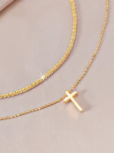 Nahaufnahme der doppelten Goldfußkette mit funkelnder Sternenkette und Kreuz-Anhänger.