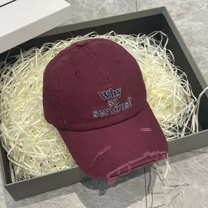 Berretto da baseball bordeaux slavato con ricamo e stile vintage di tendenza.