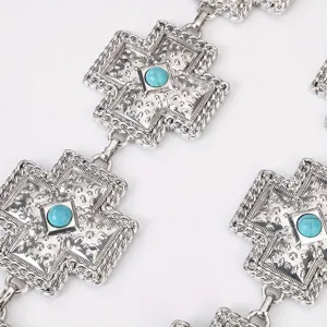 Close-up detail van vintage bohemien metalen turquoise kruis taille ketting design.