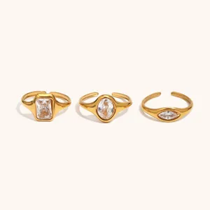 Detail shot of 18K gold plated titanium steel rings featuring square, oval, and marquise cubic zirconia.
