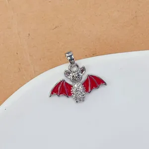 Détail de pendentif chauve-souris exquis avec ailes en émail rouge et corps en cristal.