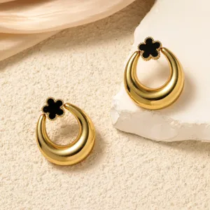 Elegant gold-tone oval earrings with chic black floral accent, perfect detail shot.