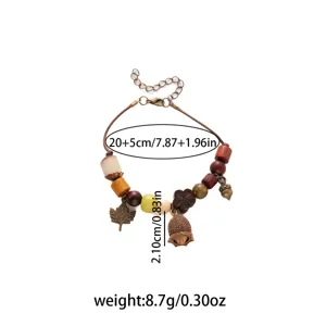 Vintage ethnic style wooden bead bracelet with acorn and maple leaf charms, detailed close-up view.
