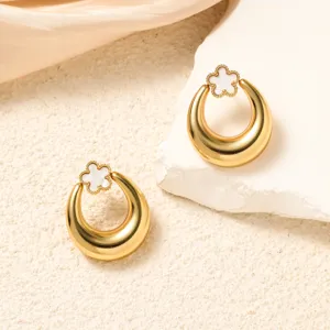 Detail view of stylish gold metal clover earrings, minimalist chic aesthetic jewelry.