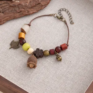 Handmade wooden bead bracelet with acorn and leaf charms, vintage ethnic style detail view.