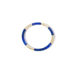 Detailed shot of a chic blue leopard print and gold tone tube bracelet featuring geometric style.