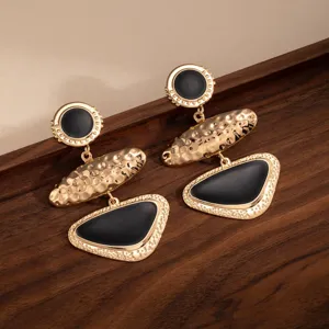 Vintage geometric oil drop metal long earrings detail shot, elegant black and gold drop design.