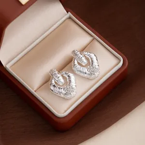 Detailed view of vintage textured diamond rhombus earrings, elegant metal geometric design.