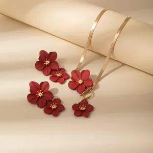 Collana a catena serpente dorata e orecchini a fiore rosso set, dettaglio gioielli retrò.