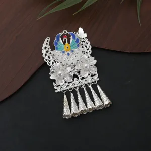 Detailed view of traditional Miao silver ethnic peacock pendant with pearls and long metal tassels.