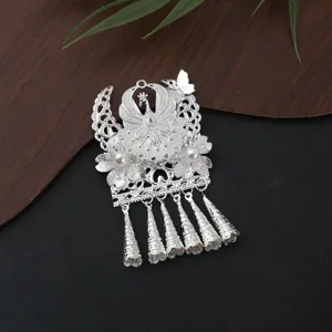 Detailed view of traditional style silver metal decorative pendant with tassels and pearls.