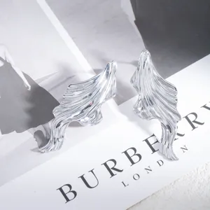 Detailaufnahme moderner metallischer unregelmäßiger Ohrringe mit eleganter glänzender Textur.
