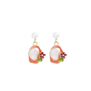 Detailed view of baroque pearl earrings with enamel floral design for elegant vintage style.