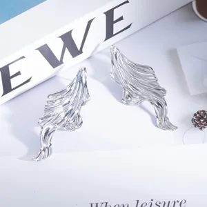 Silberne metallische unregelmäßige geometrische Ohrringe mit abstrakten fließenden Designdetails.