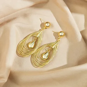Detailed view of fashionable gold metallic hollow teardrop earrings with multi-layered design.