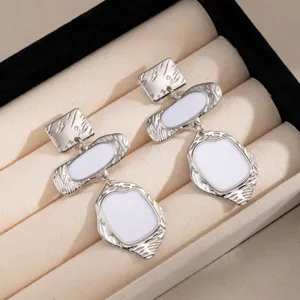 Boucles d'oreilles géométriques argentées vintage avec émail blanc pour femmes élégantes.