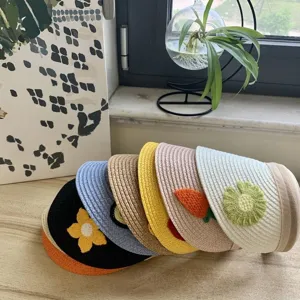 Detailansicht bunter Kindersonnenschirme mit süßen handgemachten Häkelblumen und Karottenmotiven.