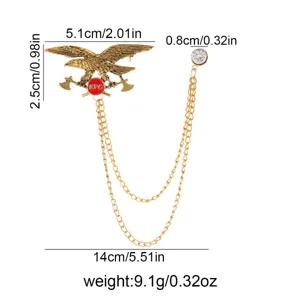 Close up detail of gold eagle brooch showing dimensions chain tassel and crystal.
