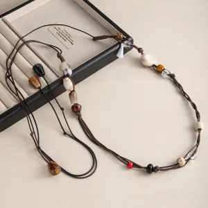 Dettaglio catena vita perline boho fatte a mano, cordino intrecciato retro con conchiglie.