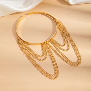 Vista detallada de brazalete geométrico dorado con cadenas colgantes múltiples.