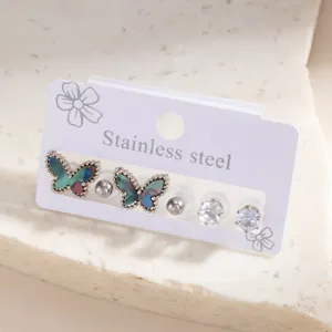 Stainless steel butterfly earring set detail, featuring iridescent shell and crystal studs.