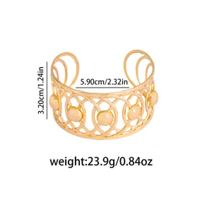Gold open cuff bracelet with geometric hollow design and round bead accents, stylish metal.