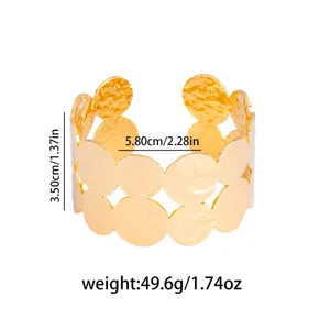 Gold-tone chunky open cuff bracelet with irregular circular cutouts, statement geometric jewelry.