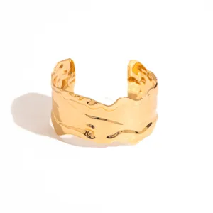 Gold wide irregular open cuff bracelet, vintage metallic geometric arm jewelry detail shot.