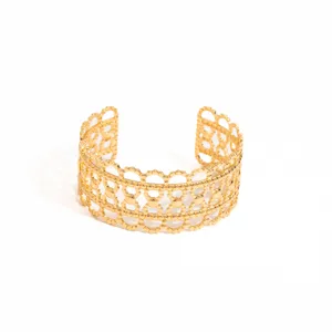 Gold-tone open cuff bracelet featuring an intricate hollow geometric beaded lace design.