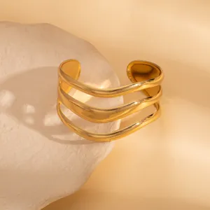 Detailed shot of a multi-strand wavy gold open cuff bracelet with a modern geometric design.