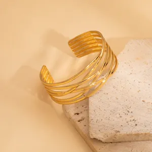 Wide gold metal cuff bracelet for women, geometric multi-strand open bangle fashion jewelry.