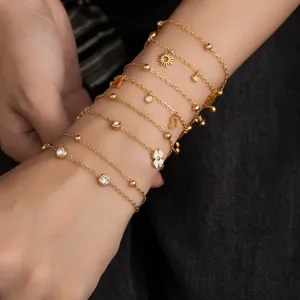 Layered gold metal chain bracelet set with cubic zirconia, sun, heart and flower charms.