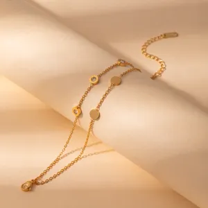 Gold layered bracelet detail shot, minimalist stainless steel round charms with sparkling crystals.