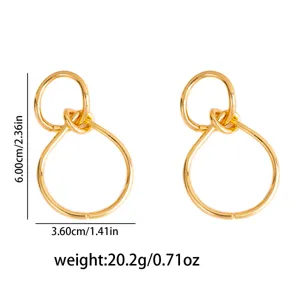Gold geometric interlocking drop earrings, vintage metal chic statement jewelry.